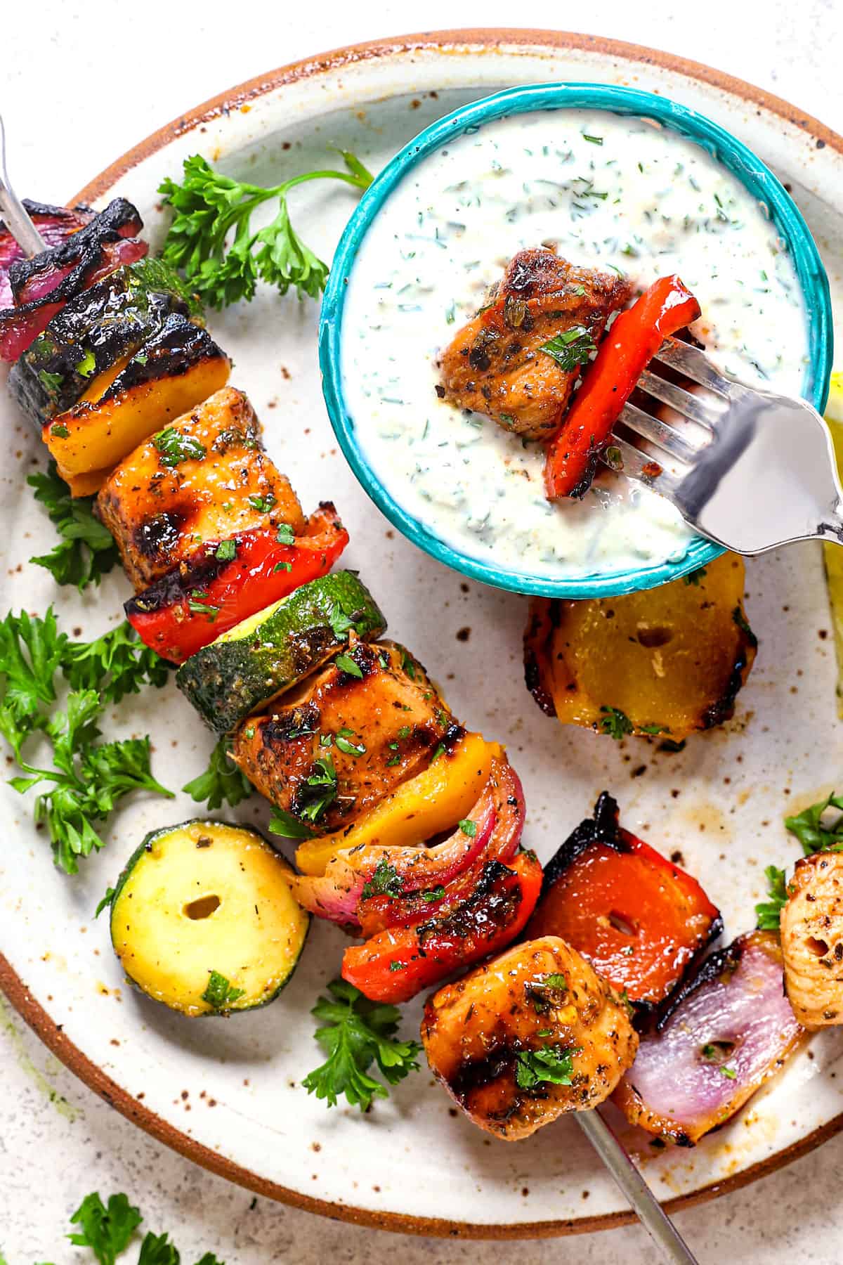 showing how to serve oven chicken kabobs (chicken kebabs) by serving on a plate with dipping sauce