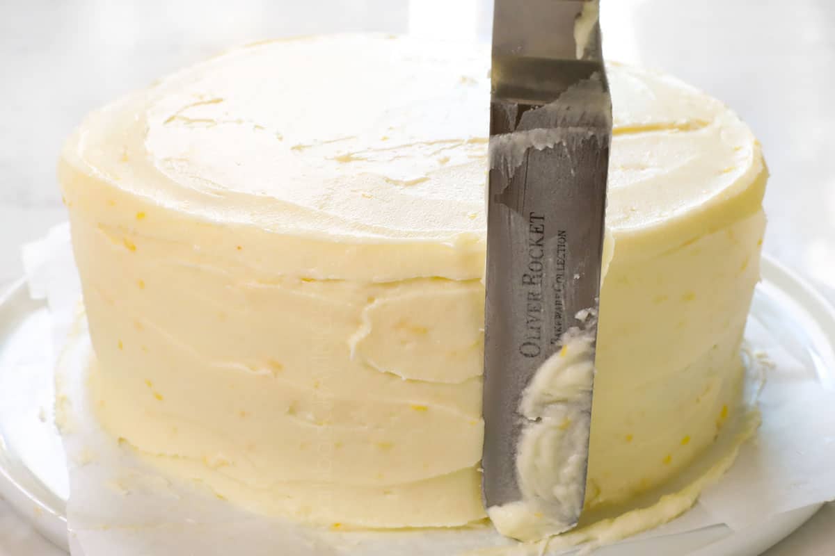 showing how to make lemon raspberry cake by applying lemon frosting