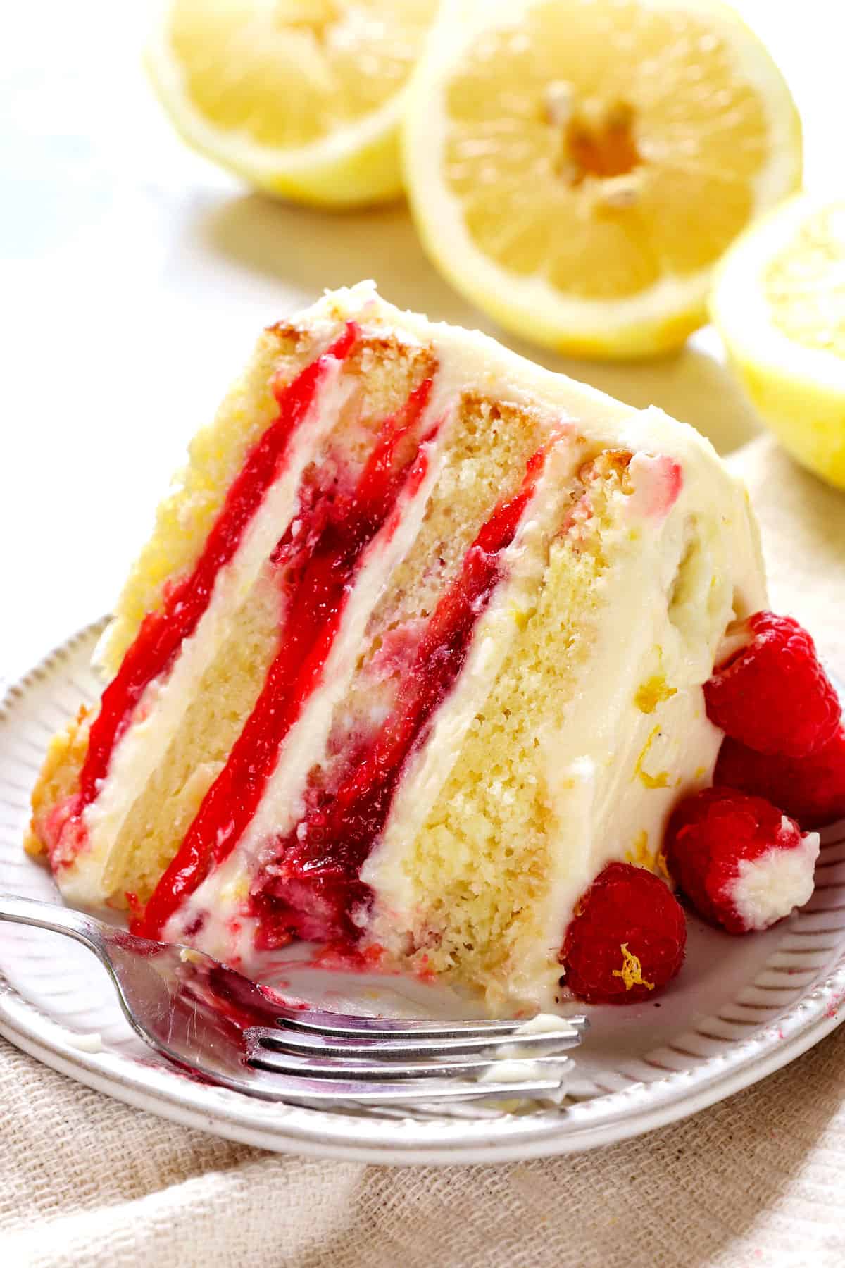 up close of a bite of of Raspberry Lemon Cake showing the raspberry filling and tender cake