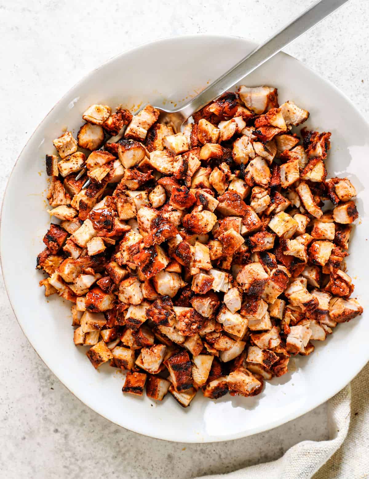 showing how to make street tacos by chopping chicken into small, bite size pieces