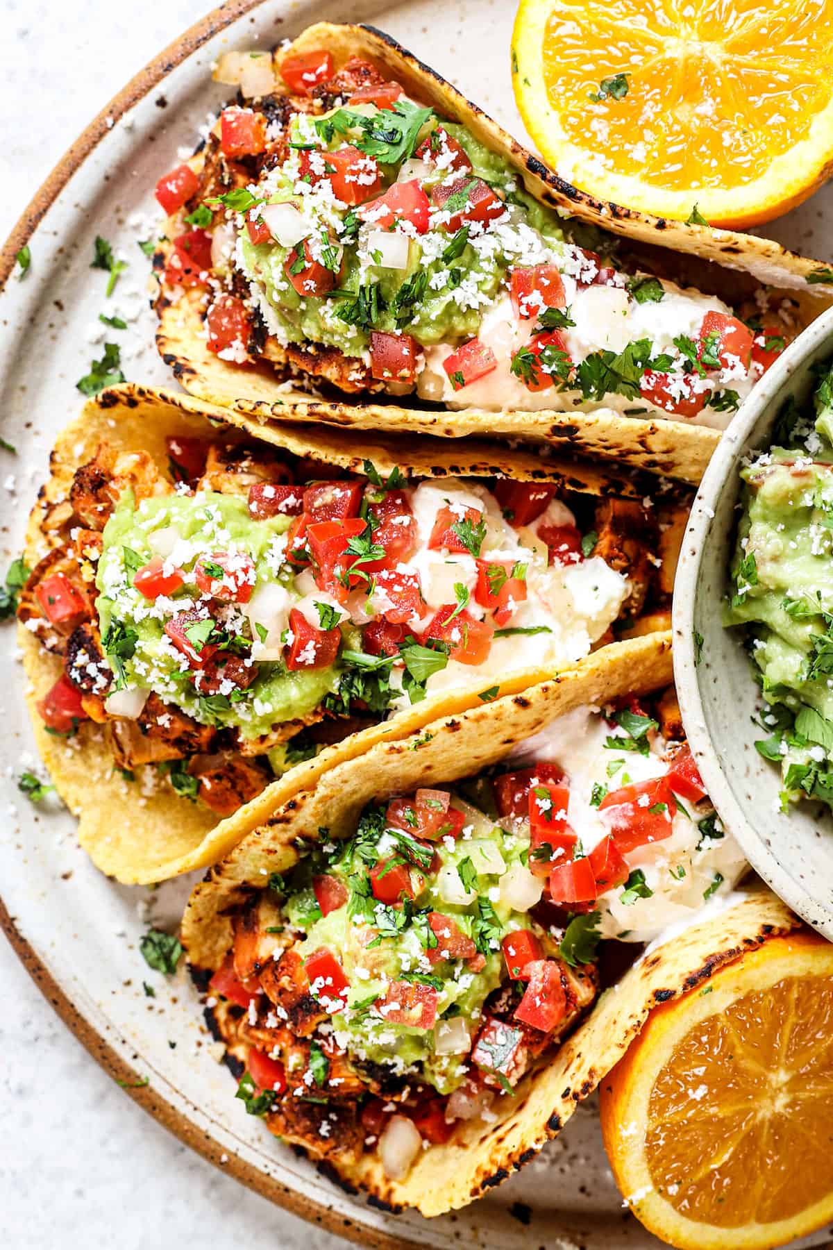 top view showing how to serve chicken street tacos with pico de gallo, guacamole and cotija cheese