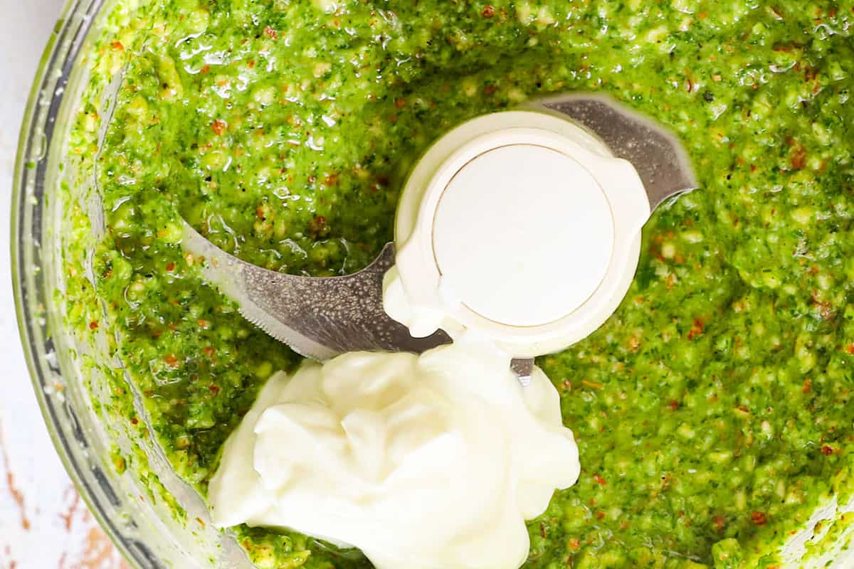 showing how to make red potato salad by adding Greek yogurt to the dressing and blending until creamy