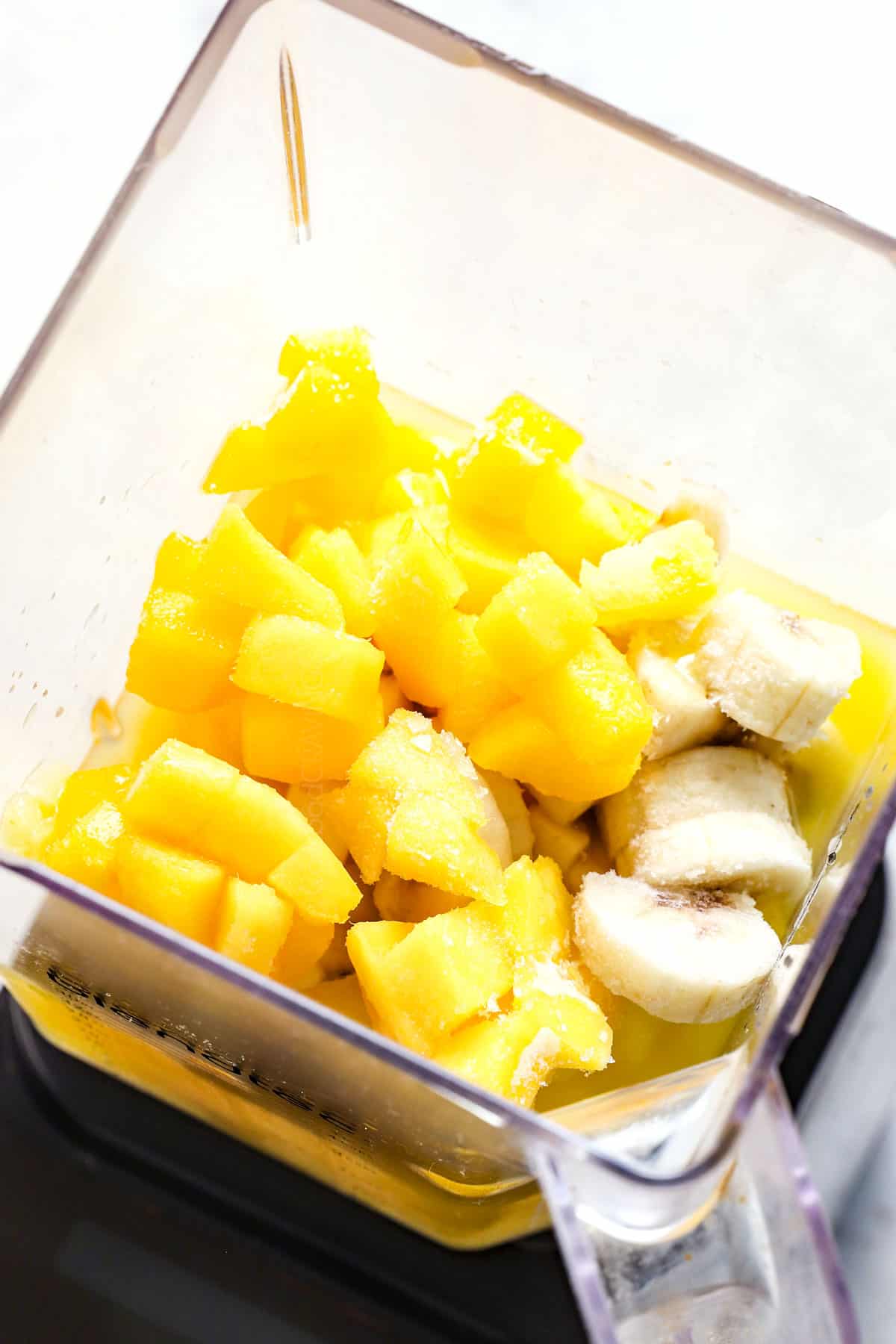 Showing how to make smoothie by adding the fruit into the blender, followed by the liquid