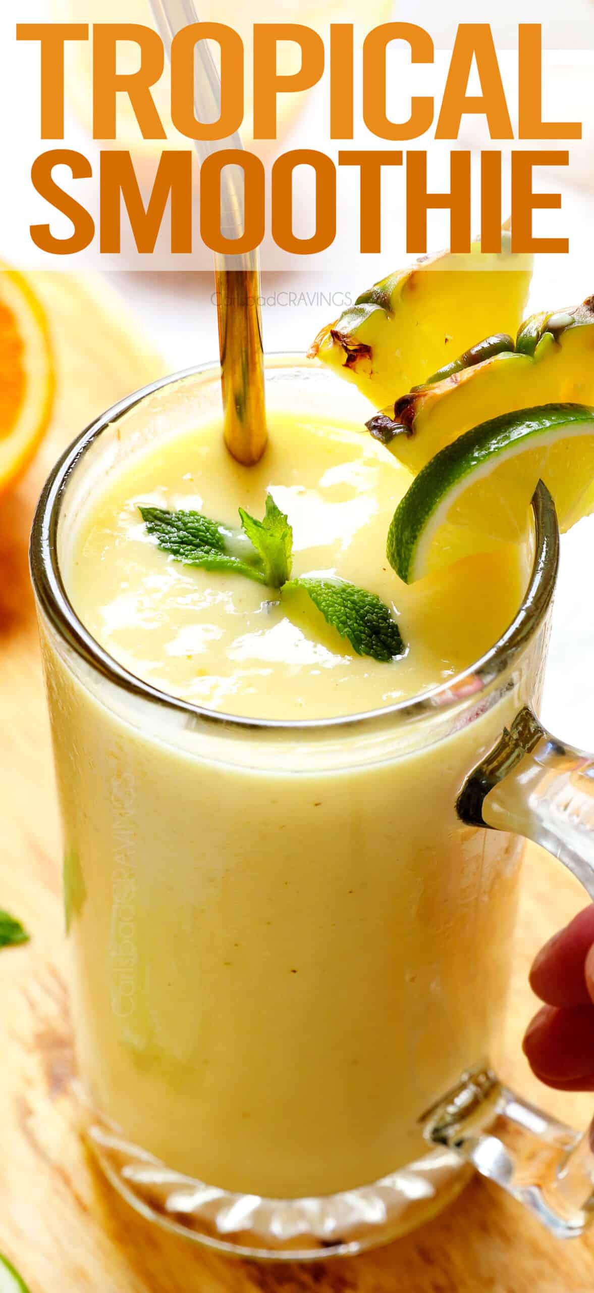 Tropical Smoothie in a glass with a straw, garnished by mint