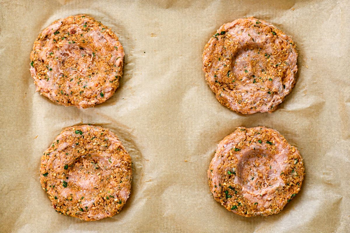 showing how to make turkey burgers recipe by dimpling the middle of the patties so they cook evenly