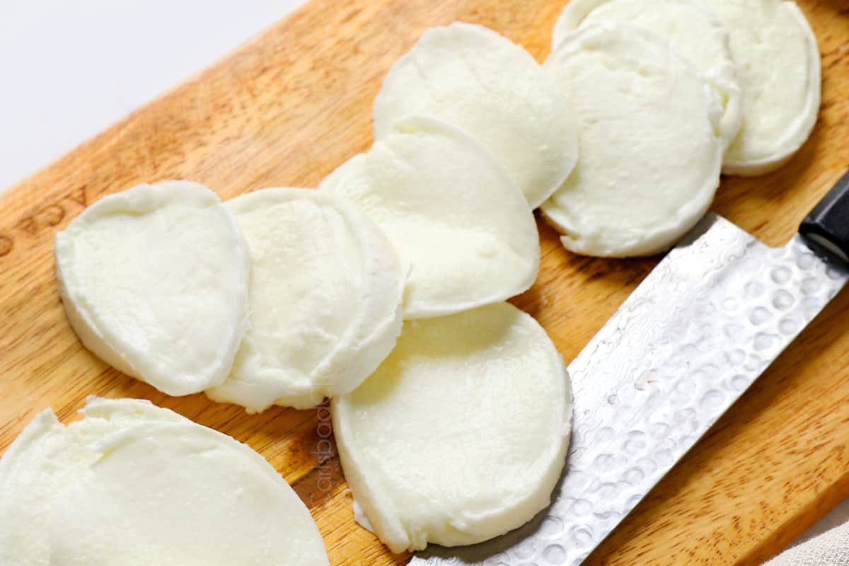 showing how to make Caprese by slicing mozzarella