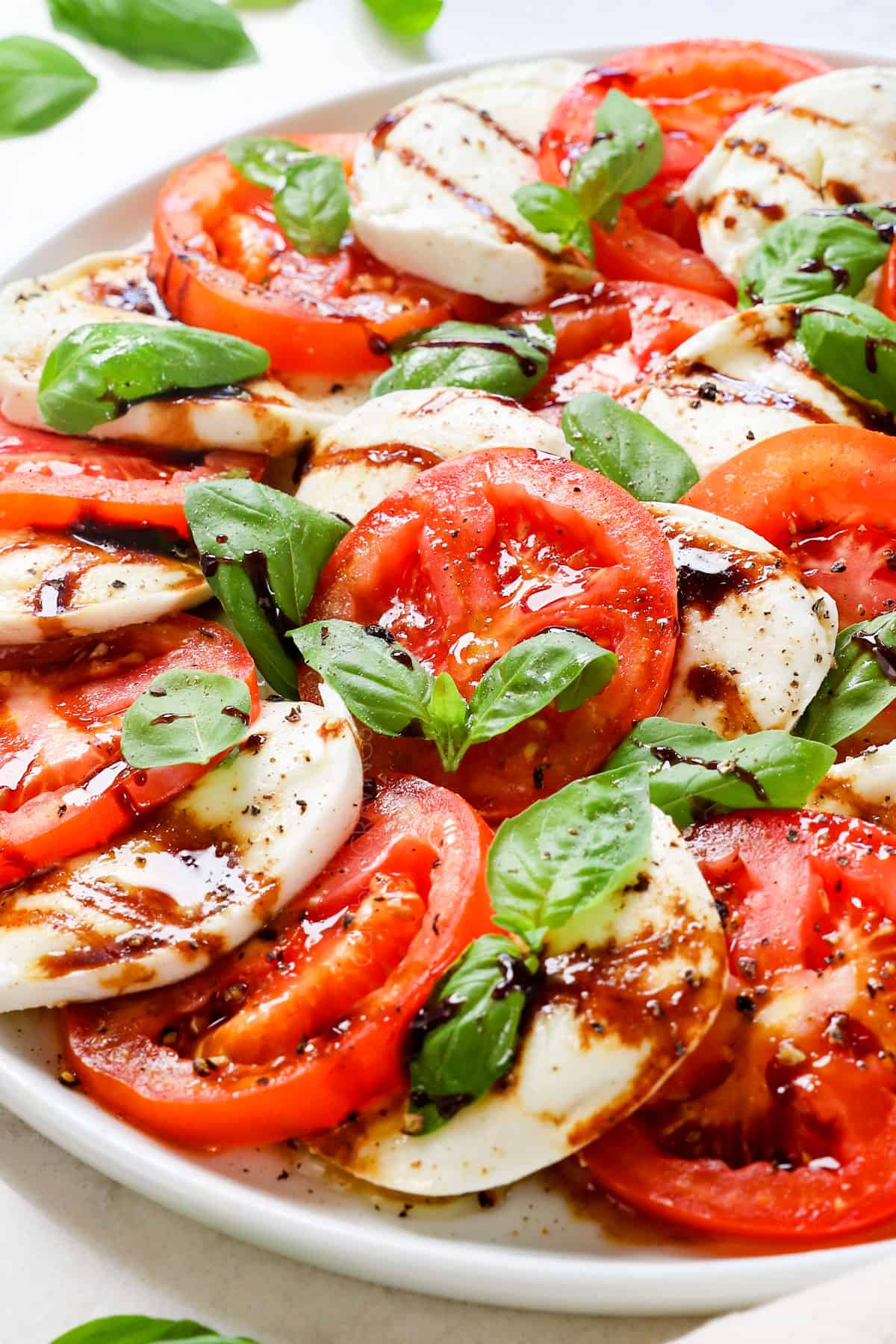 serving Caprese Salad recipe drizzled with balsamic reduction
