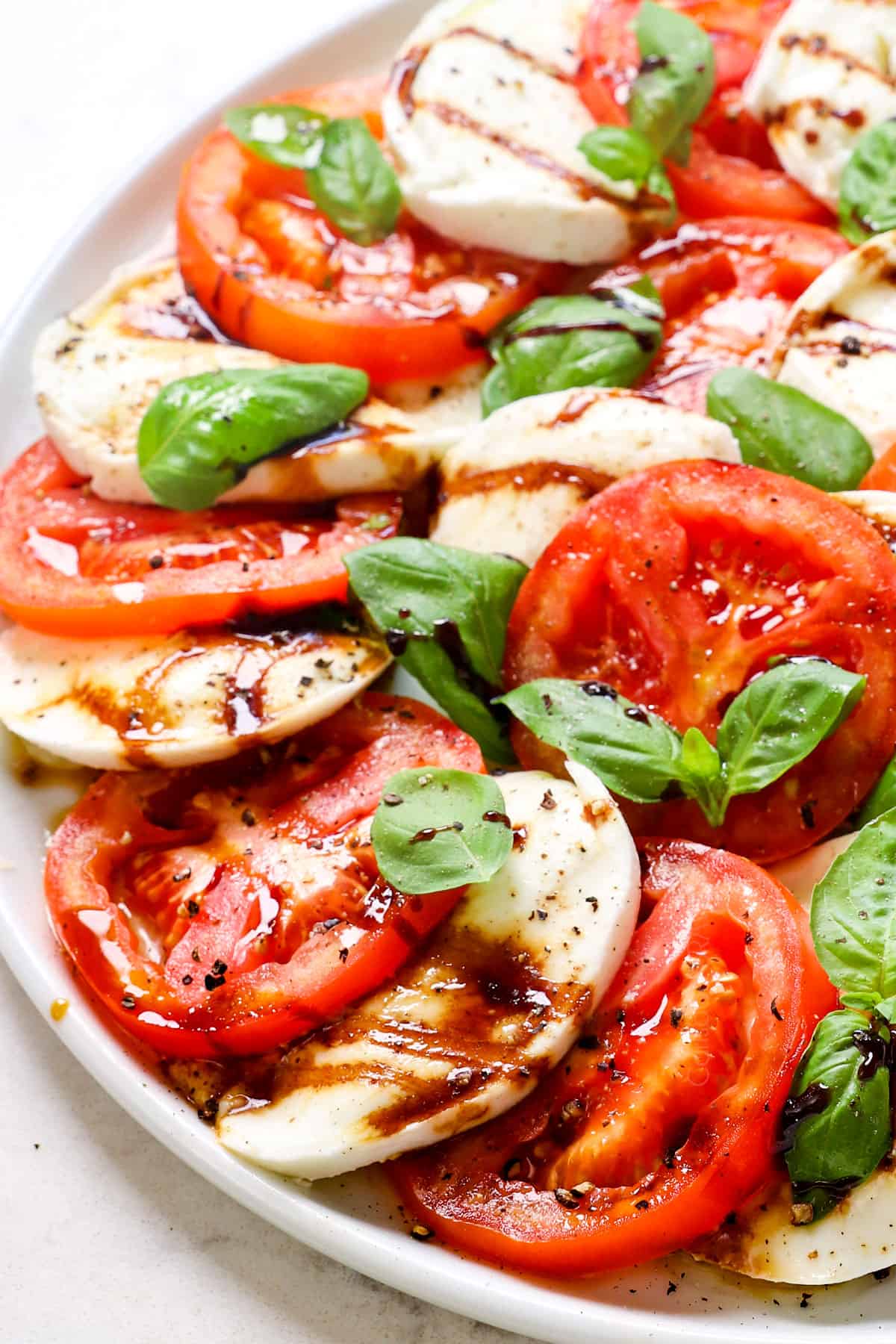 serving Caprese Salad recipe drizzled with balsamic reduction