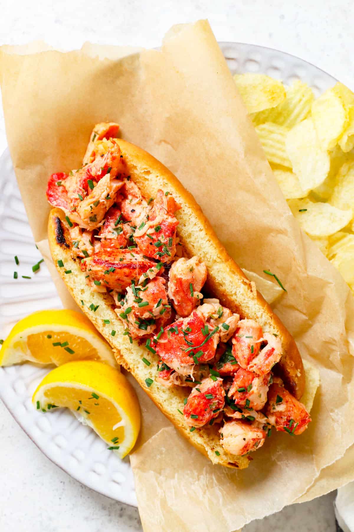 top view of serving Main lobster roll on a plate with potato chips