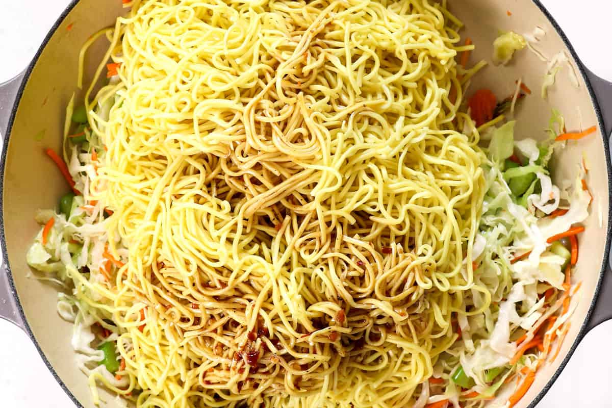 showing how to make chow mein by adding chow mein noodles and stir fry sauce