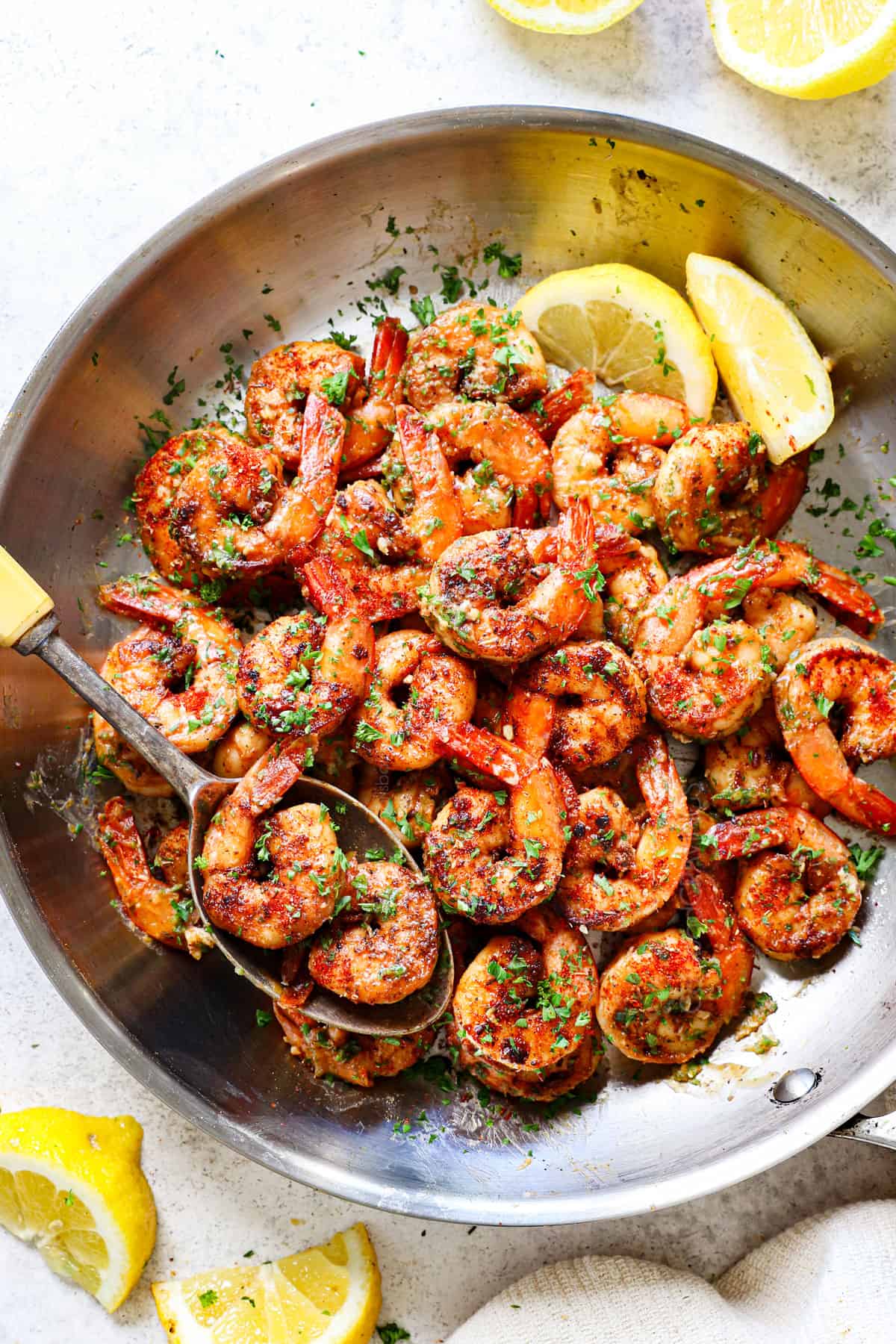showing how to make Cajun shrimp recipe by tossing sautéed shrimp with butter and parsley