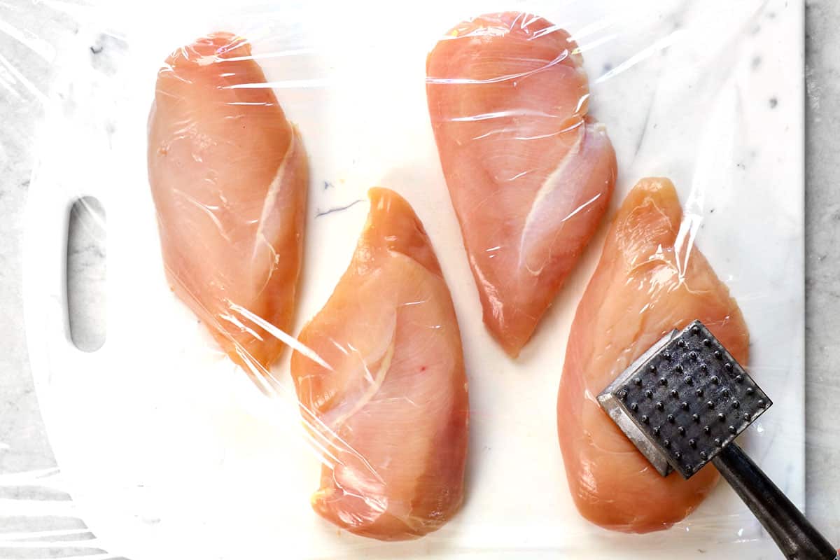 process shot showing how to make oven baked chicken breast by pounding chicken to an even thickness with a meat mallet