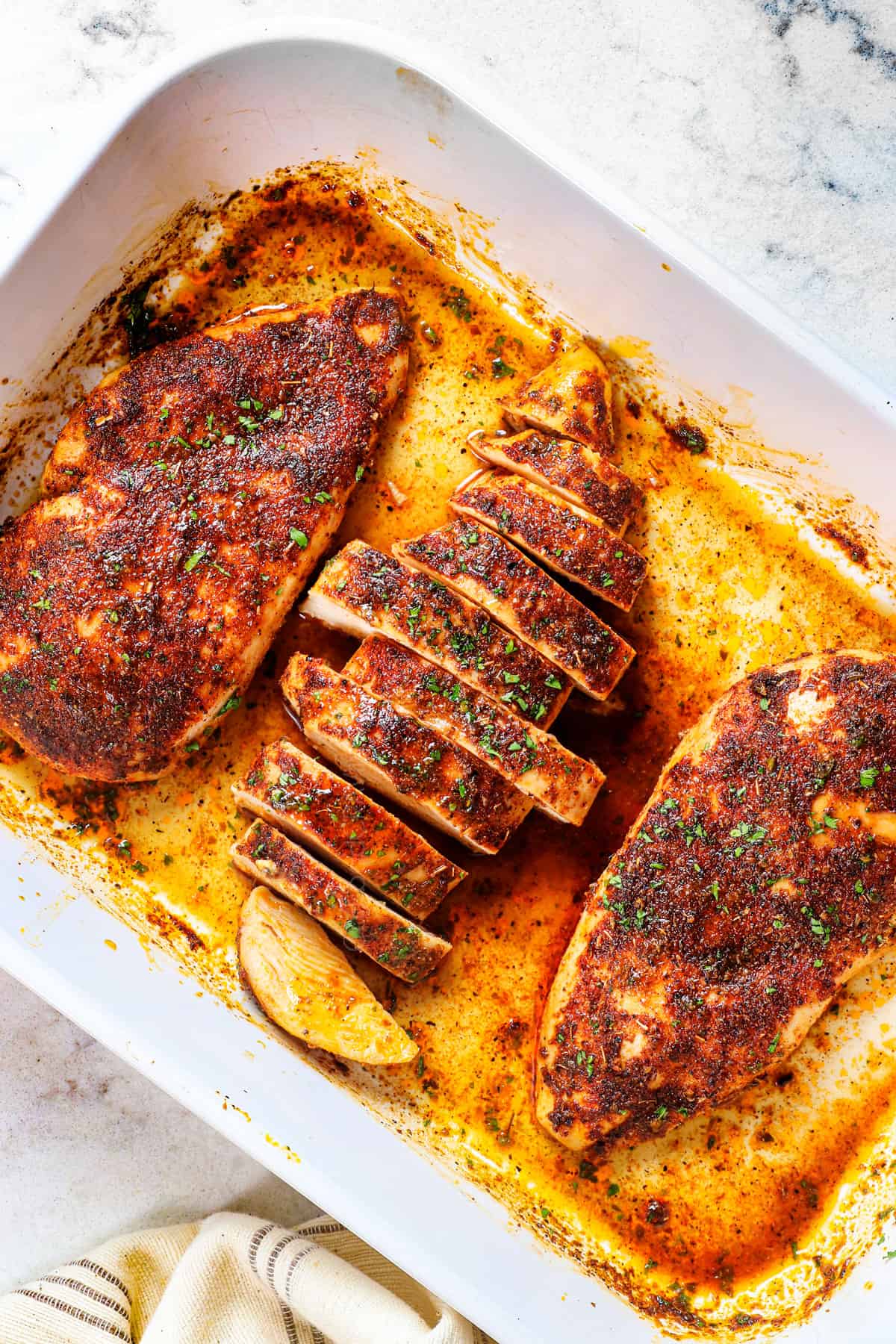 baked boneless chicken breast sliced in a baking dish