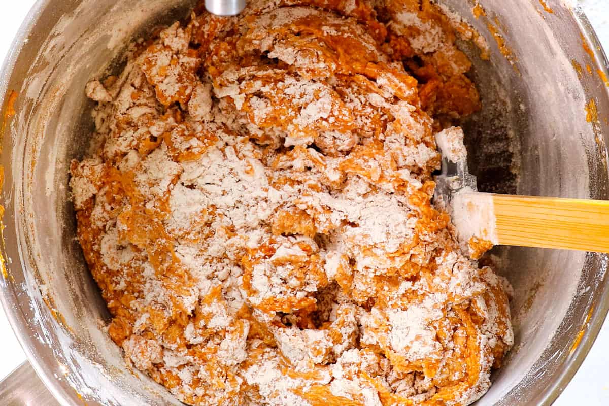 showing how to make pumpkin chocolate chip cookies by stirring dry ingredients into wet ingredients