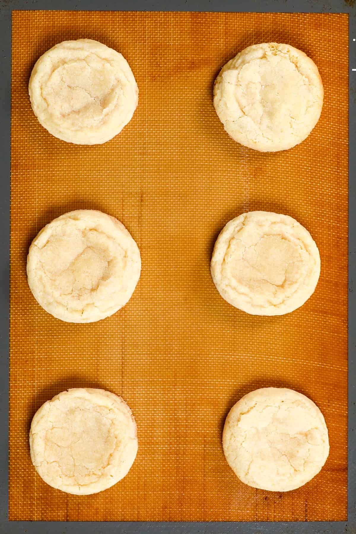 showing how to make sugar cookie recipe by baking the cookies on a nonstick mat