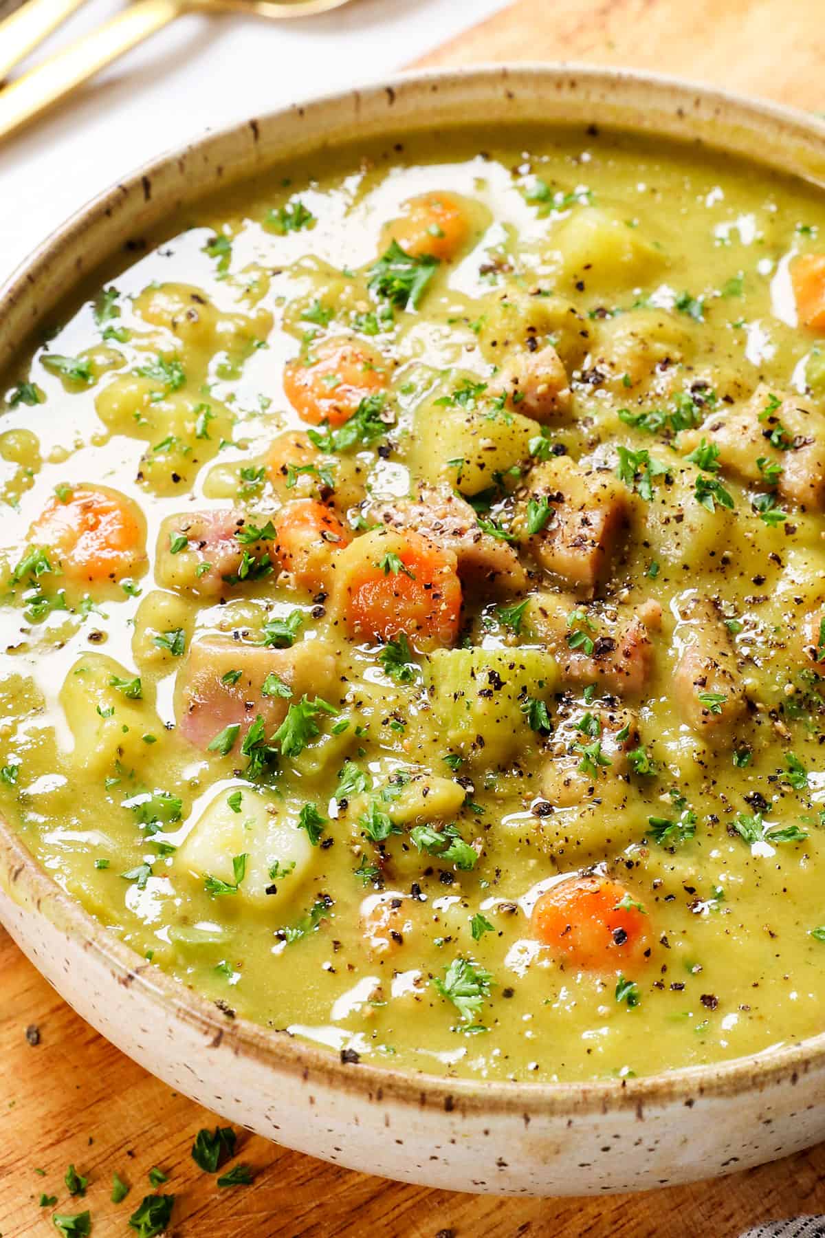 showing how to serve split pea soup with ham in a bowl garnished with parsley