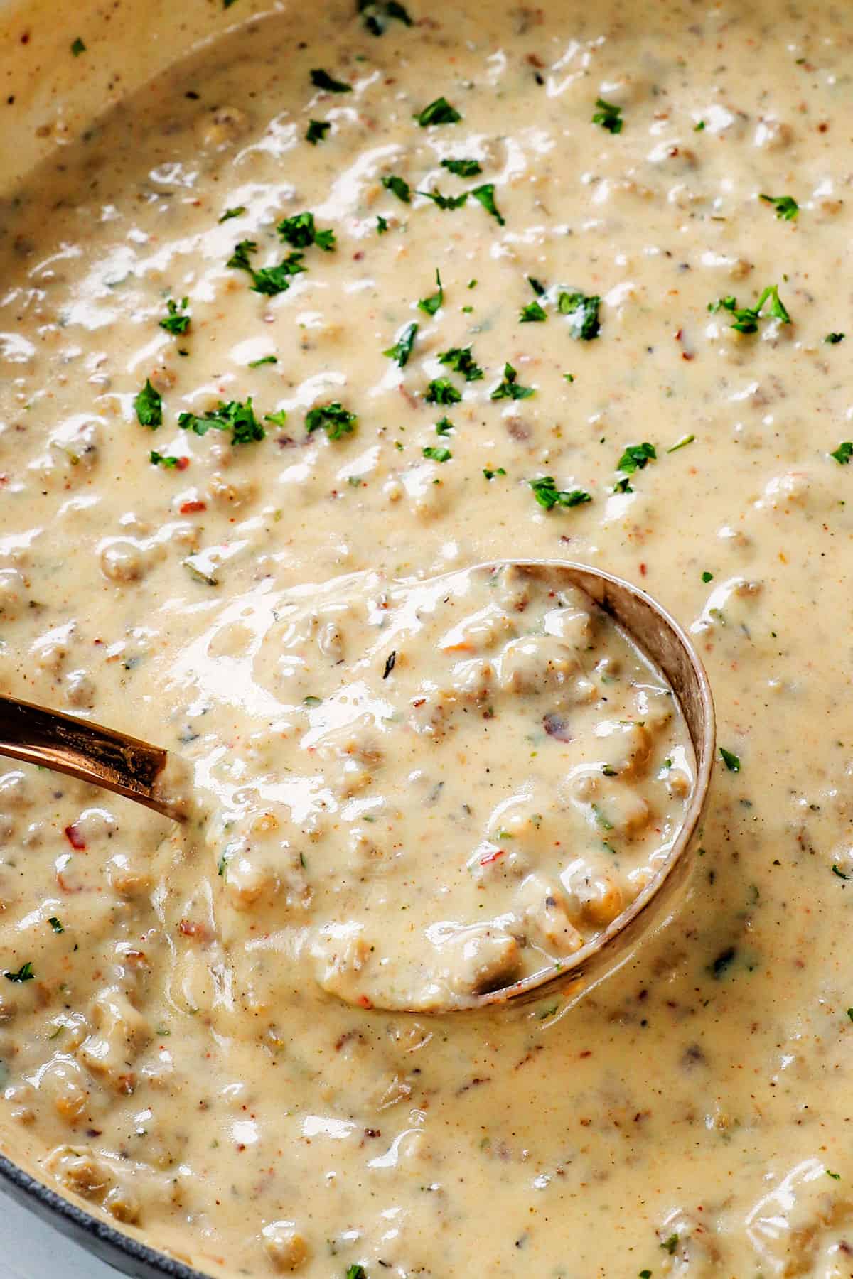 showing how to make biscuit and gravy casserole by seasoning sausage gravy to taste