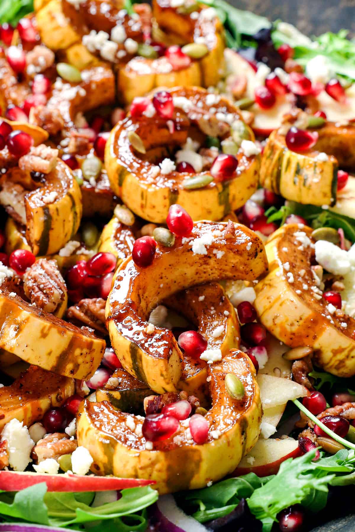 showing how to use delicata squashy by adding to greens and tossing with nuts and seeds