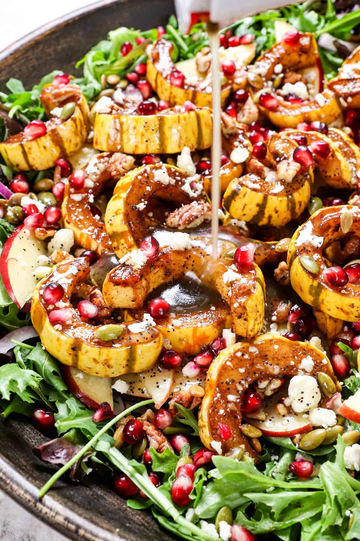 showing how to make winter salad recipe by adding dressing