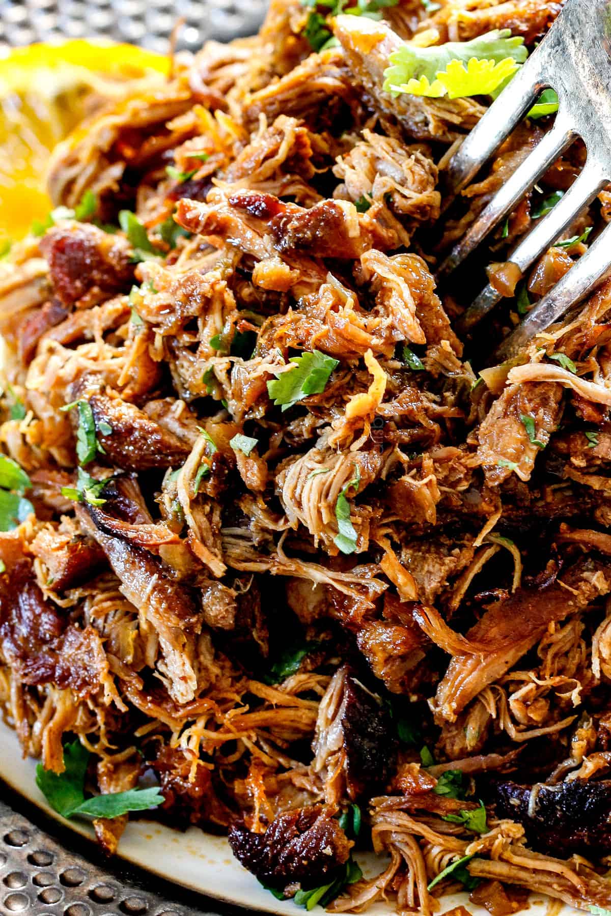 showing how to make carnitas tacos recipe by shredding the pork