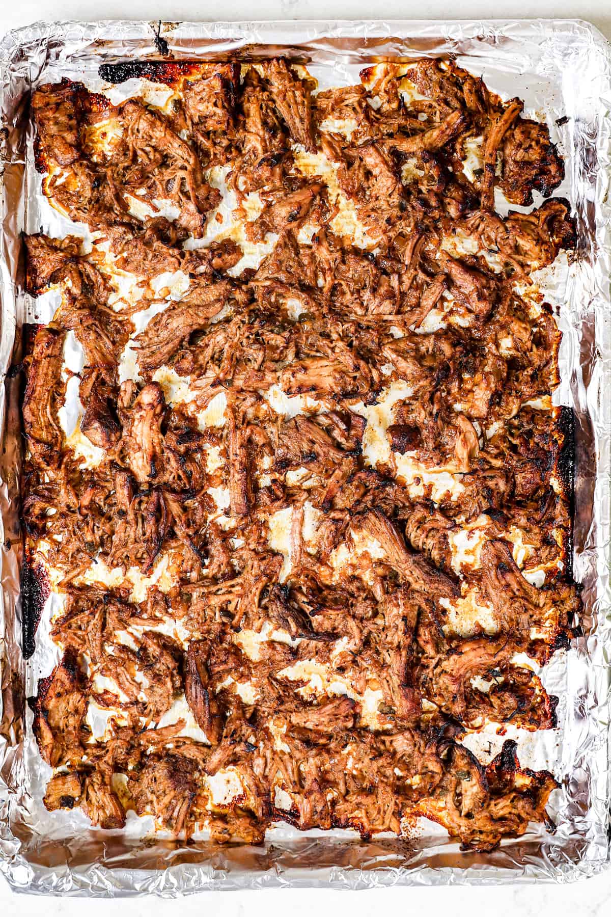 showing how to make carnitas tacos by broiling the ends until crispy