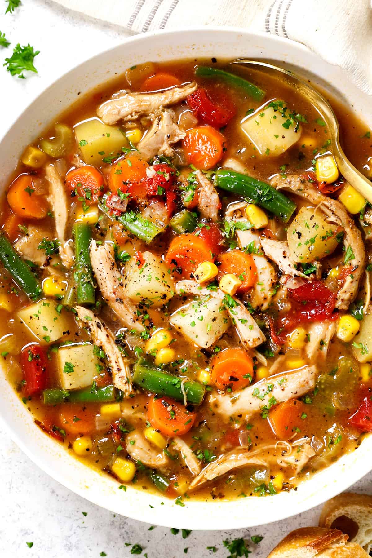 showing how to serve chicken vegetable soup in a bowl garnished with parsley