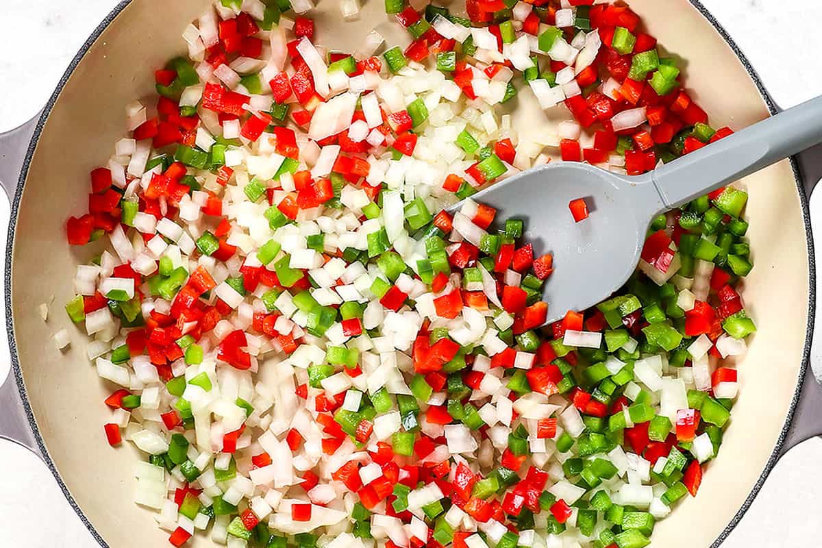 showing how to make shakshuka by sautéing onions and bell peppers