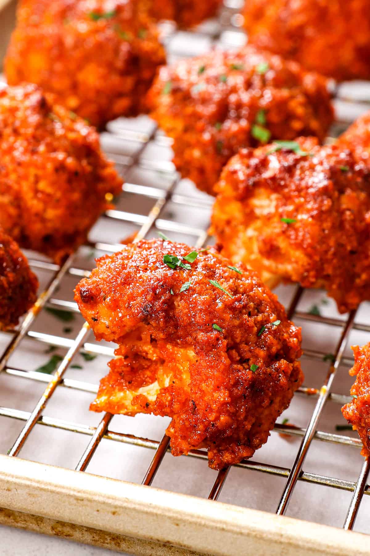 up close of buffalo cauliflower wings on a baking sheet showing how extra crispy they are with panko