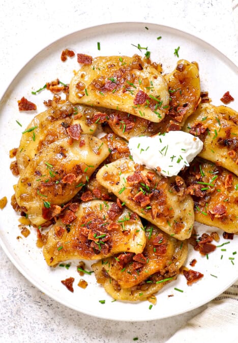 top view of pierogi recipe being served on a plate with sour cream