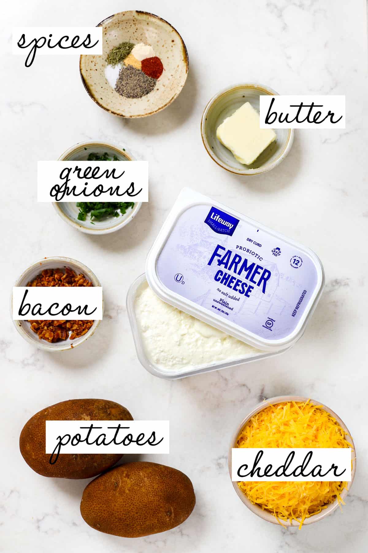 top view showing pierogi filling ingredients: farmers cheese, cheddar, bacon, green onions, potatoes, butter and spices