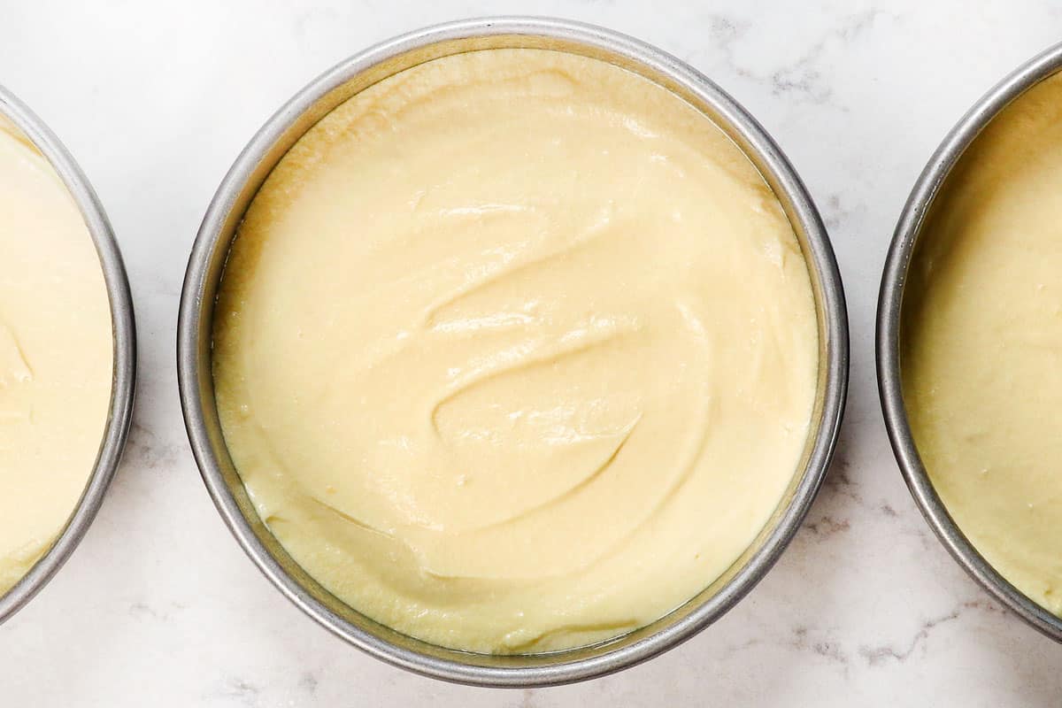 showing how to make Chantilly cake by adding batter to cake pans