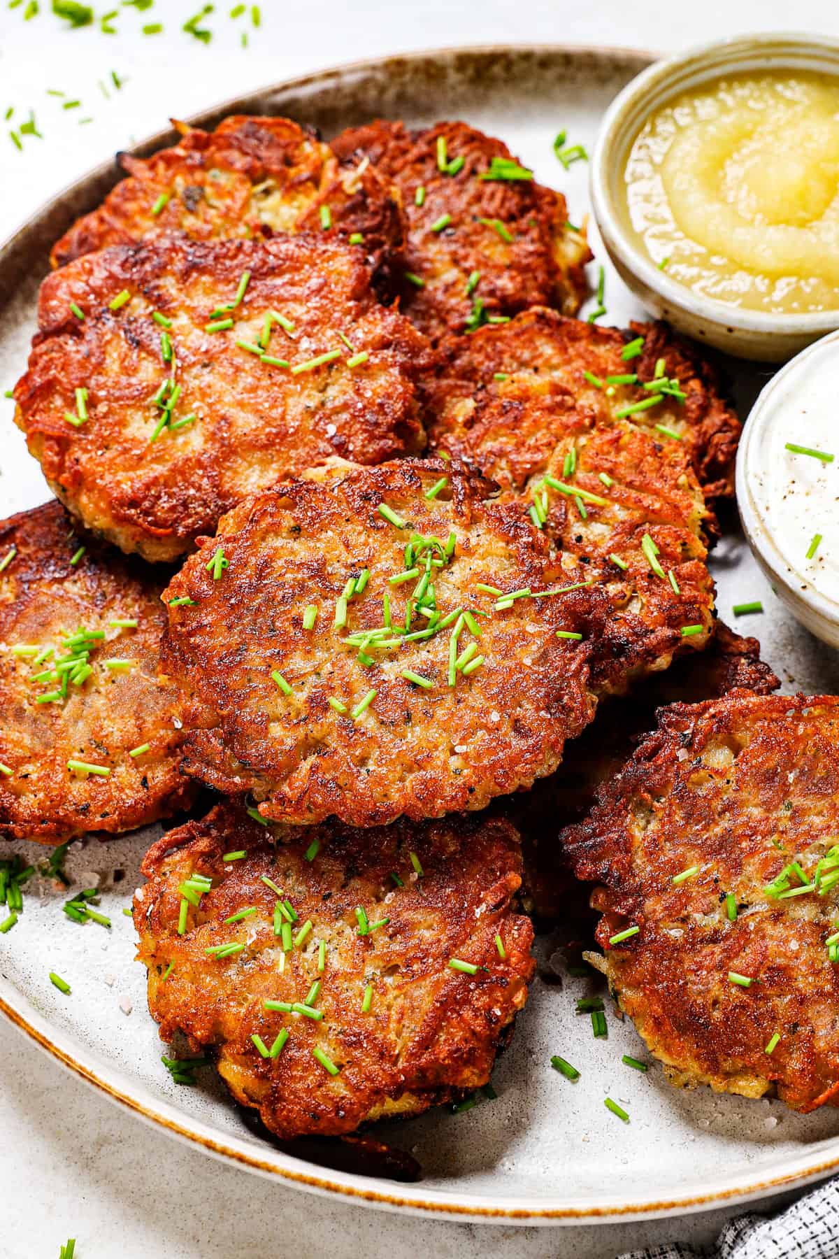 showing how to serve German potato pancakes on a platter with sour cream and applesauce