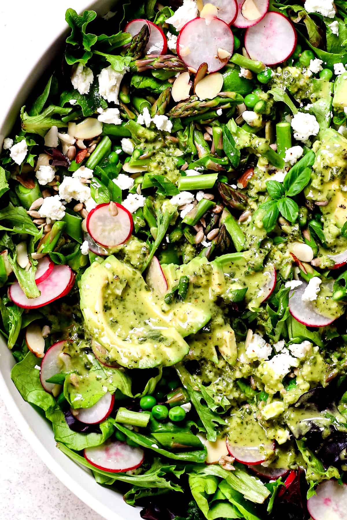 showing how to make spring salad by adding dressing