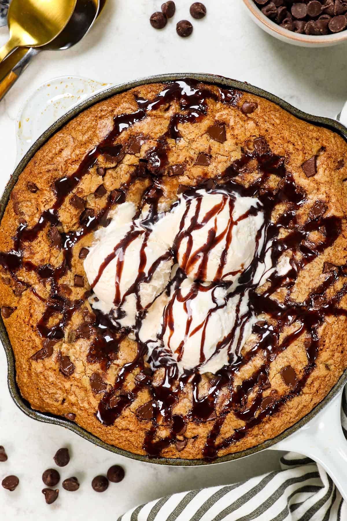 showing how to serve pizookie recipe with chocolate chips drizzled with chocolate sauce
