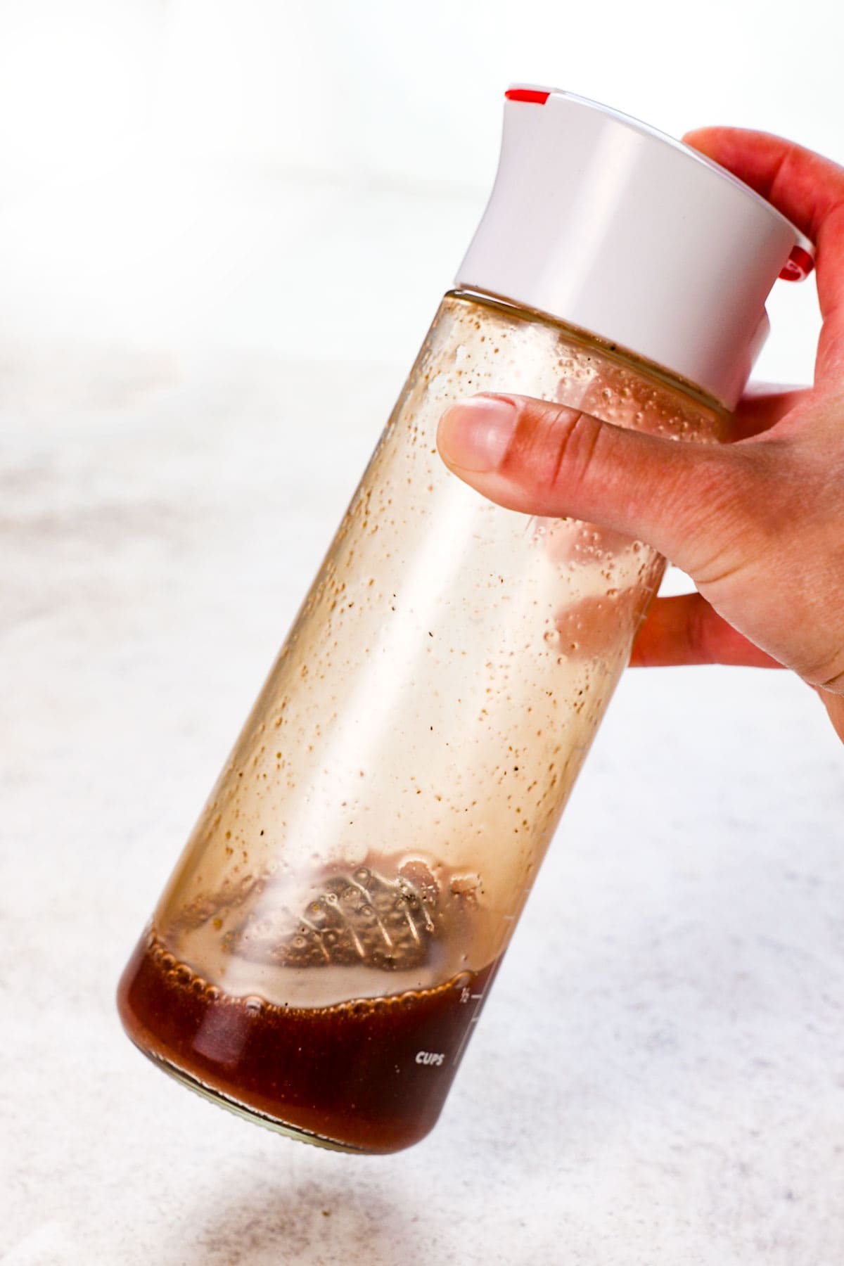 showing how to make summer salad recipe by whisking together the cherry balsamic vinaigrette