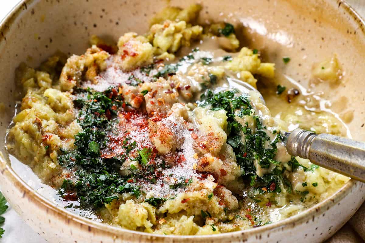 showing how to make baba ghanoush by adding the tahini, lemon juice, olive oil, parsley, garlic, and spices.