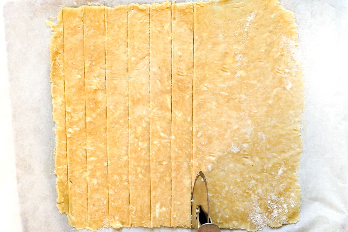 showing how to make apple pie by slicing the lattices for the pie topping