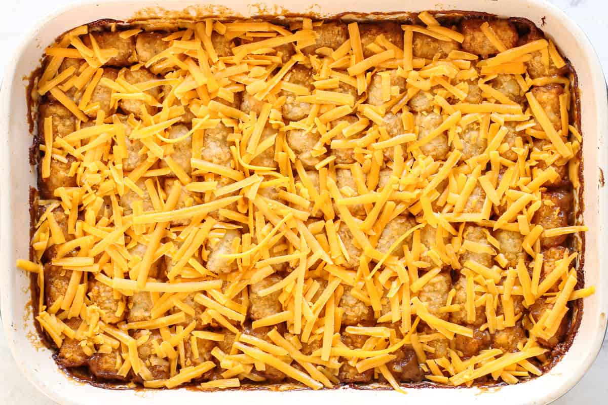 showing how to make tater tot casserole by baking the tater tot casserole, then adding cheese and baking 5 more minutes