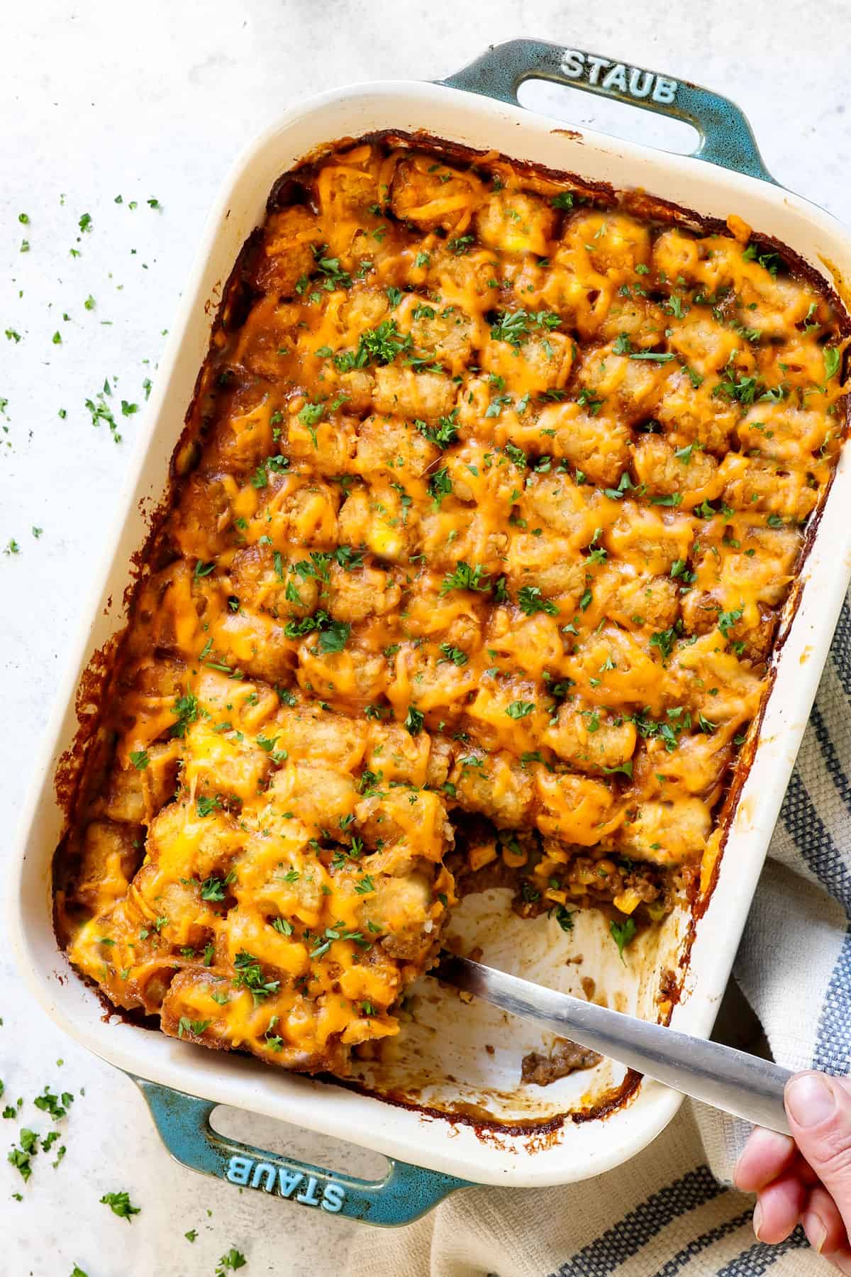showing how to make tater tot casserole by baking until the cheese is melted
