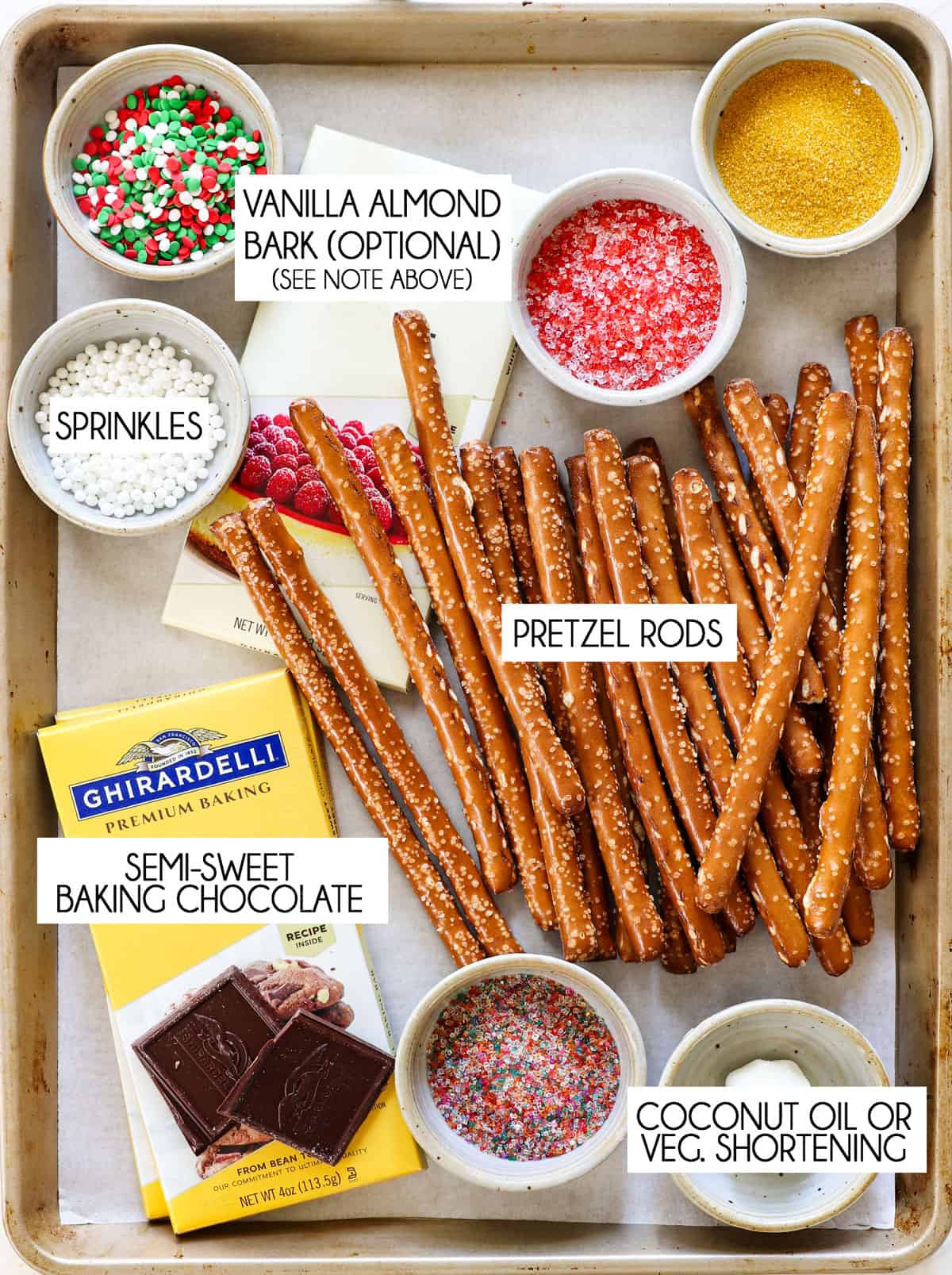 top view showing chocolate dipped pretzel ingredients: pretzels, semi-sweet baking chocolate, sprinkles, vegetable shortening and almond bark
