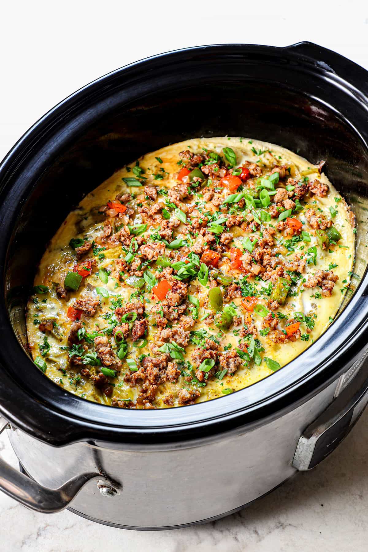 breakfast casserole crockpot topped with green onions and cilantro in the slow cooker
