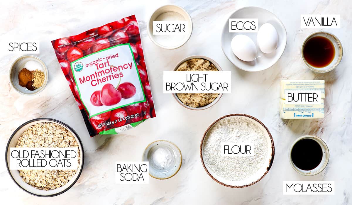 top view of ingredients for cherry blossom cookie: tart cherries, oats, flour, eggs, brown sugar, granulated sugar