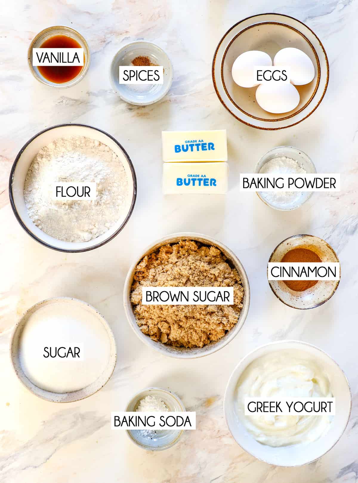 top view showing coffee cake ingredients: flour, brown sugar, granulated sugar, Greek yogurt or sour cream, vanilla, eggs, cinnamon, baking powder, butter