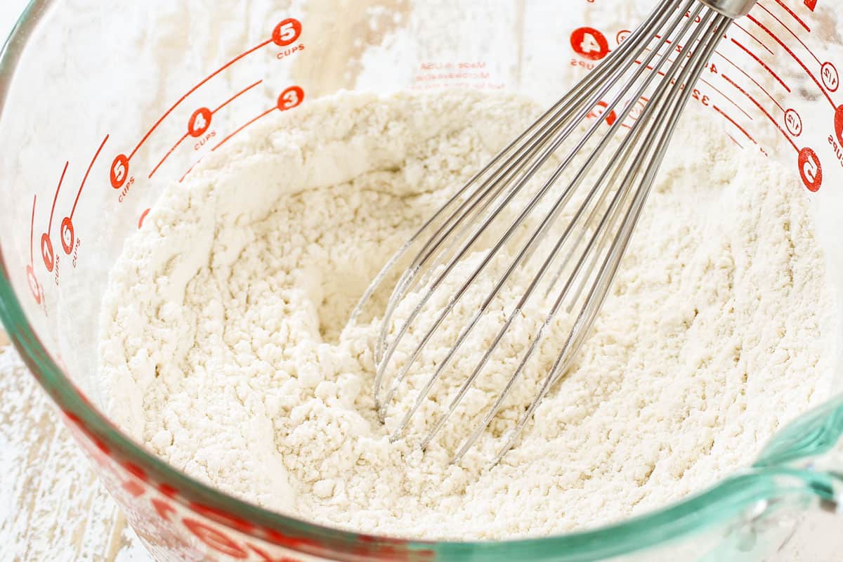 showing how to make coffee cake by mixing together the flour, baking powder, baking soda and salt in a bowl