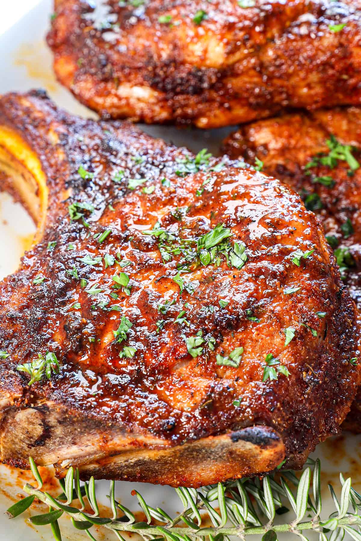 up close of pork chop air fryer spice rubbed and garnished with fresh parsley