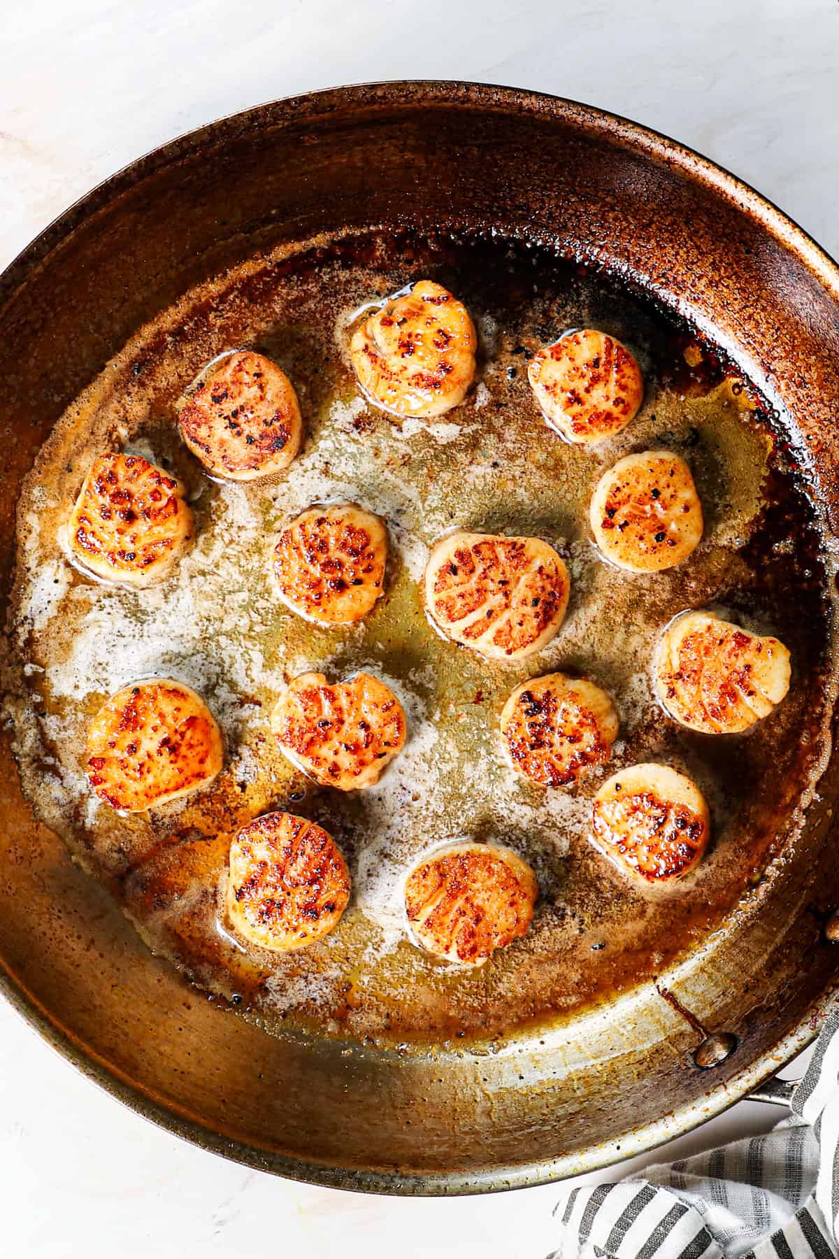 showing how to make pan seared scallops by searing both sides until golden in butter