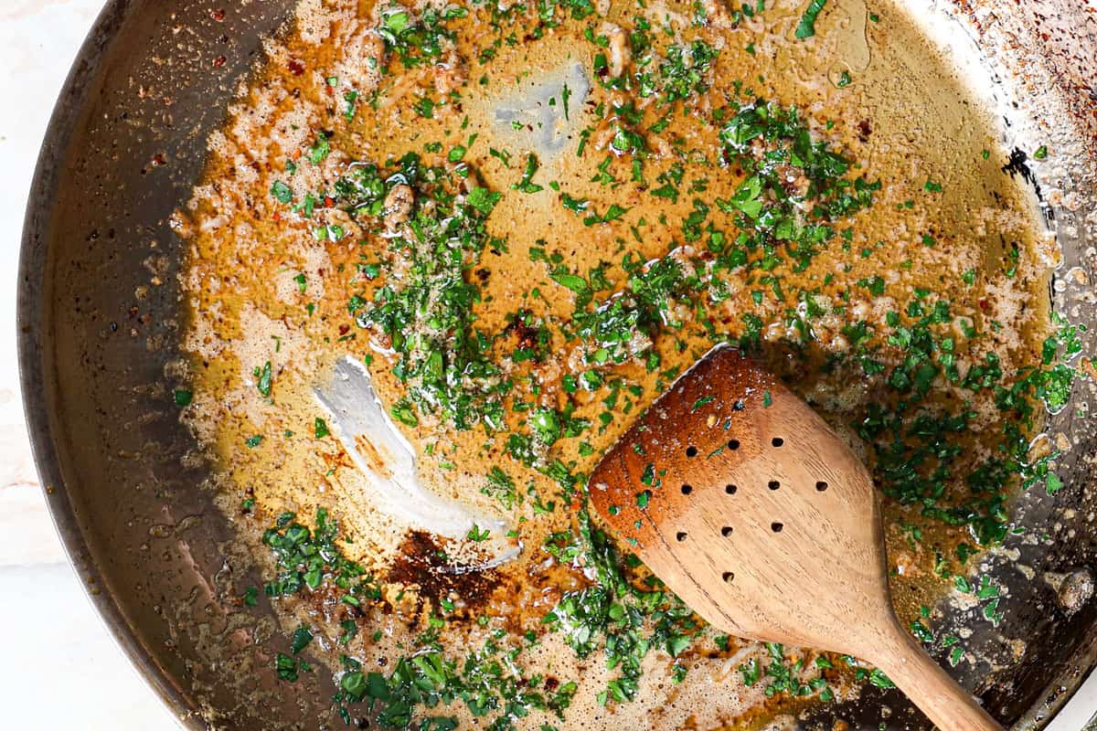 showing how to make pan seared scallops by making lemon garlic butter sauce by sautéing garlic, then adding lemon and parsley