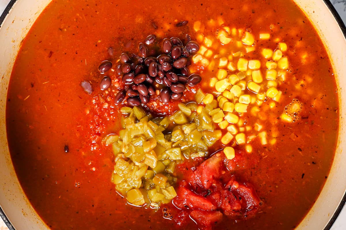 showing how to make chicken taco soup recipe by returning the chicken to the pot, followed by the chicken broth, black beans, corn, diced tomatoes, green chiles, and bouillon.