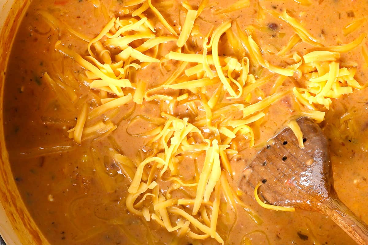 showing how to make chicken taco soup by stirring in cream cheese and cheese