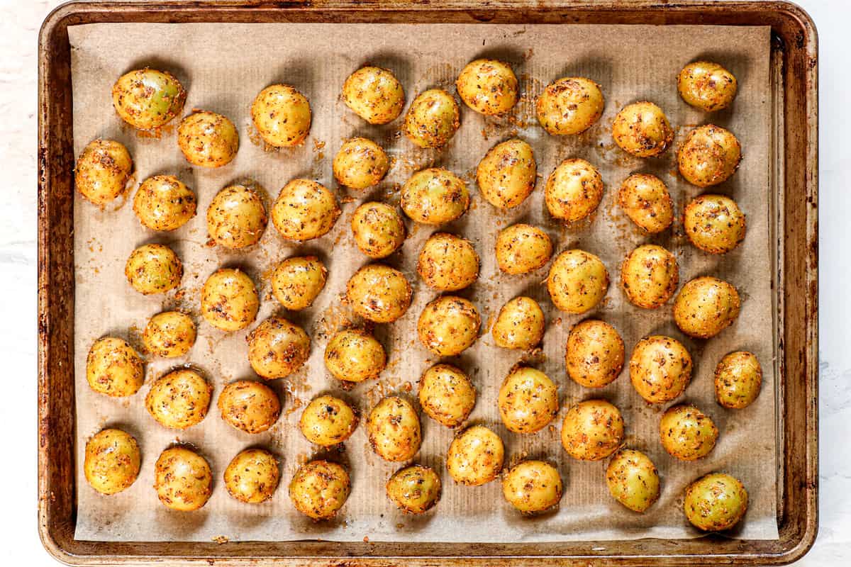 showing how to make roasted potatoes by arranging the potatoes cut side down on a baking sheet